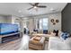 Living room with a modern electric fireplace, large sectional sofa with blue pillows and bright sunlight at 837 E 98Th Ave # 403, Thornton, CO 80229