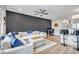 Bright living room with modern ceiling fan, dark accent wall and a sectional sofa with blue pillows at 837 E 98Th Ave # 403, Thornton, CO 80229
