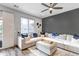 Bright living room with modern ceiling fan, dark accent wall and a sectional sofa with blue pillows at 837 E 98Th Ave # 403, Thornton, CO 80229