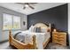 Comfortable main bedroom featuring a ceiling fan, large window, and stylish accent wall at 837 E 98Th Ave # 403, Thornton, CO 80229