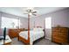Spacious bedroom with hardwood furniture, a ceiling fan, and ample natural light at 7656 Depew St # 1802, Arvada, CO 80003