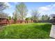 Expansive backyard with lush lawn, playhouse, swing set, and privacy fencing at 9574 Las Colinas Dr, Lone Tree, CO 80124