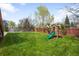 Beautifully landscaped backyard features a lush green lawn, trees, playset, and swing at 9574 Las Colinas Dr, Lone Tree, CO 80124