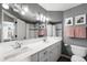 Bathroom with double sink, white cabinets, grey walls, and a shower-tub combination with tiled walls at 9574 Las Colinas Dr, Lone Tree, CO 80124