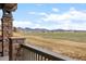 Scenic view from the porch with stone columns overlooking a sprawling field and distant mountains at 8555 W Quarles Pl, Littleton, CO 80128