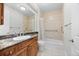 Bathroom with granite counters, tiled shower over tub, and handy access rails at 8555 W Quarles Pl, Littleton, CO 80128