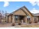 Beautiful exterior view of a tan home with stone porch supports at 8555 W Quarles Pl, Littleton, CO 80128