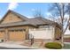 Exterior view of a tan home with a two car garage, and a small fenced in front yard at 8555 W Quarles Pl, Littleton, CO 80128