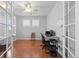 Bright home office with hardwood floors, white trim, ceiling fan, and natural light from windows with plantation shutters at 8555 W Quarles Pl, Littleton, CO 80128