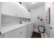 Bright laundry room featuring a washer and dryer, white cabinets, and a folding counter at 8555 W Quarles Pl, Littleton, CO 80128