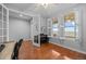 Bright living room featuring hardwood floors, white trim, piano, and natural light from large windows with plantation shutters at 8555 W Quarles Pl, Littleton, CO 80128