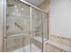 Modern walk-in shower featuring frameless glass doors and stylish tile work at 8555 W Quarles Pl, Littleton, CO 80128