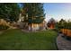 An expansive backyard features a lush lawn, mature trees and rock landscaping at 10837 Fox Sedge Way, Highlands Ranch, CO 80126
