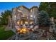 The backyard has a patio with a fire pit and seating, with a tranquil pond and surrounding landscape at 10837 Fox Sedge Way, Highlands Ranch, CO 80126