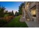 An expansive backyard features a lush lawn, stairs to upper deck and mature trees at 10837 Fox Sedge Way, Highlands Ranch, CO 80126