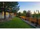 A private backyard has lush lawn, mature trees, rock landscaping and wood fence at 10837 Fox Sedge Way, Highlands Ranch, CO 80126