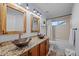 Bathroom featuring a double sink vanity with copper vessel sinks, wooden framed mirrors and updated fixtures at 10837 Fox Sedge Way, Highlands Ranch, CO 80126