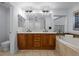 Bathroom featuring a double sink vanity, soaking tub, and modern light fixtures at 10837 Fox Sedge Way, Highlands Ranch, CO 80126