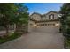 Three car garage home with mature tree, brick landscaping, and large driveway, perfect for a Gathering at 10837 Fox Sedge Way, Highlands Ranch, CO 80126