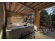 Backyard covered hot tub area with bench, stone pillar, and surrounding landscaping creating a relaxing retreat at 10837 Fox Sedge Way, Highlands Ranch, CO 80126