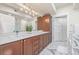 Bathroom featuring double sinks, wood cabinets, and marble floors at 1080 E 13Th Ave # 301, Denver, CO 80218