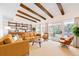 Bright living room with exposed beams, stylish furniture, a bookshelf, and sliding doors to the outside at 3883 S Elm St, Denver, CO 80237