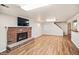 Basement area featuring a brick fireplace, wood floors, and ample space for entertaining and relaxation at 7079 S Tamarac Ct, Centennial, CO 80112