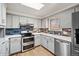 Well-lit kitchen with stainless steel appliances, modern backsplash, and ample cabinet space at 7079 S Tamarac Ct, Centennial, CO 80112