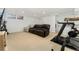 Finished basement with a home gym area, comfy seating, and a partially built in bar at 1730 Ward Cir, Franktown, CO 80116