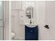 Bathroom featuring a stylish navy blue vanity with an oval mirror and modern lighting fixtures at 1730 Ward Cir, Franktown, CO 80116