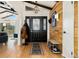 Inviting entryway with hardwood floors, coat rack, and wood-paneled accent wall at 1730 Ward Cir, Franktown, CO 80116