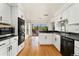 Modern kitchen with stainless steel appliances, white cabinets and hardwood floors at 1730 Ward Cir, Franktown, CO 80116