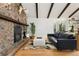 Cozy living room features a stone fireplace, wood beams, and hardwood floors at 1730 Ward Cir, Franktown, CO 80116