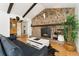 Living room with stone fireplace, wooden beams, and hardwood floors at 1730 Ward Cir, Franktown, CO 80116
