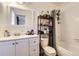 Well-lit bathroom with a vanity, storage rack, and a shower-tub combination at 3855 S Monaco St # 209, Denver, CO 80237