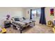 Bright bedroom featuring a comfortable bed, window with curtains, and neutral carpet at 3855 S Monaco St # 209, Denver, CO 80237