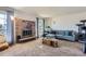 Cozy living room featuring a brick fireplace, plush carpet, and ample natural light at 3855 S Monaco St # 209, Denver, CO 80237