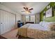 Bedroom featuring a workstation, closet with doors, ceiling fan, and bed with floral bedding at 9800 Mayfair St # E, Englewood, CO 80112