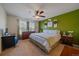 Comfortable bedroom featuring green accent wall, a ceiling fan, and dresser at 9800 Mayfair St # E, Englewood, CO 80112