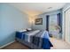 Light blue bedroom with carpet, a window, white closet doors, and a bed with blue striped blanket at 9800 Mayfair St # E, Englewood, CO 80112