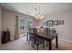 Dining room with a dark wood table, stylish chandelier, and sliding door to the outdoor space at 9800 Mayfair St # E, Englewood, CO 80112