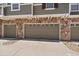 Attached three car garage with stone accents and a paved driveway at 9800 Mayfair St # E, Englewood, CO 80112