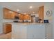 Well-lit kitchen with wood cabinets and a breakfast bar at 9800 Mayfair St # E, Englewood, CO 80112