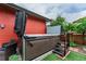Backyard featuring a hot tub with steps, surrounded by green artificial grass and a charming patio area at 2868 Kingston St, Denver, CO 80238