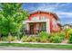 Charming two-story home with orange siding, inviting front porch, and well-manicured landscaping at 2868 Kingston St, Denver, CO 80238