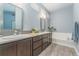 Bright and spacious main bathroom with dual sinks, large soaking tub, and modern fixtures at 2868 Kingston St, Denver, CO 80238