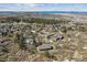 Wide aerial shot of houses nestled among trees and vegetation in a neighborhood with mountain views in the distance at 53 Taylor Ct, Castle Rock, CO 80104