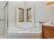 Bright bathroom with a glass shower, soaking tub, and a vanity, featuring wood trim at 53 Taylor Ct, Castle Rock, CO 80104