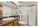 Bathroom with a white sink, dark brown countertop, a shower with sliding glass doors, and good lighting at 7500 E Dartmouth Ave # 22, Denver, CO 80231