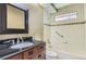 Well-lit bathroom featuring tile finishes, a vanity with solid surface counter, and a built-in tub at 7500 E Dartmouth Ave # 22, Denver, CO 80231